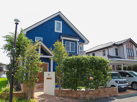 青い壁と三角屋根が印象的。今年、庭をリフォームしてガレージを拡張。家族で庭づくりを楽しんでいる