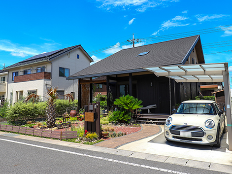 大きな屋根、どっしりとした構え。山小屋風の家に庭の緑や可憐な花々がよく映える